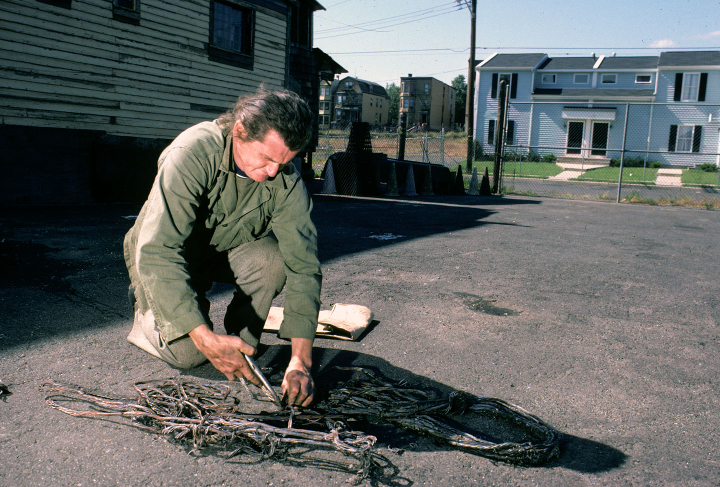14-Kea Tawana separating copper from brass in peeled cables to sell to a junk dealer, Orange at 14th, Newark, 1987_